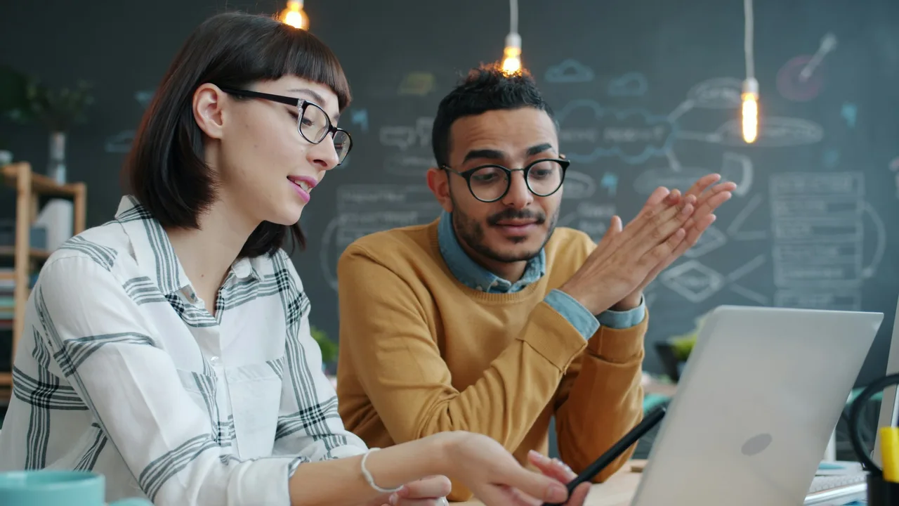Dos personas revisan una propuesta tecnológica en una computadora portátil.